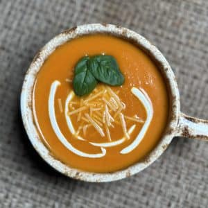 Tomato bisque soup with basil sour cream and parmesan on top